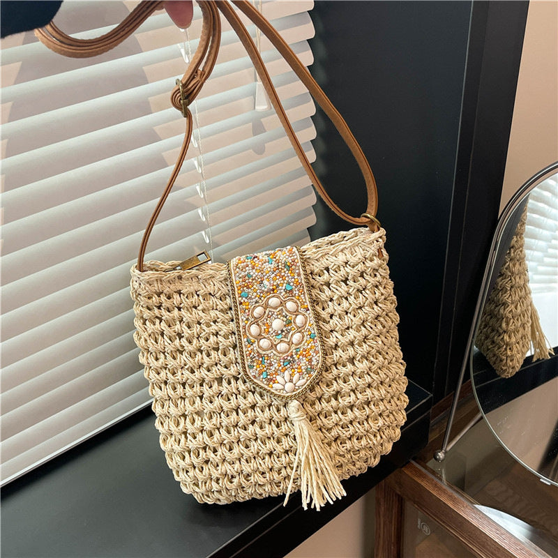 Beige straw crochet crossbody bag with beaded flap and tassel fringe